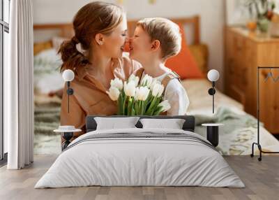 Happy woman and boy with flowers touching noses Wall mural