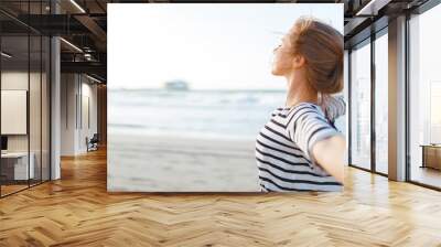 happy woman enjoying freedom with open hands on sea Wall mural