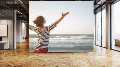 happy woman enjoying freedom with open hands on sea Wall mural