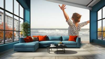 happy woman enjoying freedom with open hands on sea Wall mural