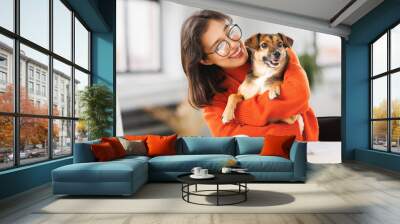 happy woman freelancer working on laptop remotely from home together with pet dog Wall mural