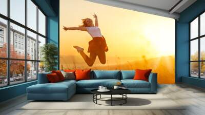 Happy woman  jump,  rejoices,  on sunset in nature Wall mural