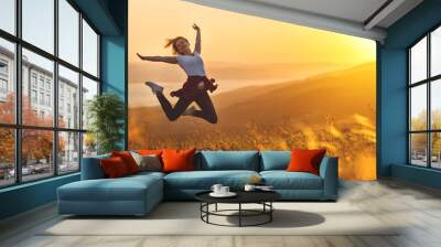 Happy woman jumping and enjoying life  at sunset in mountains. Wall mural