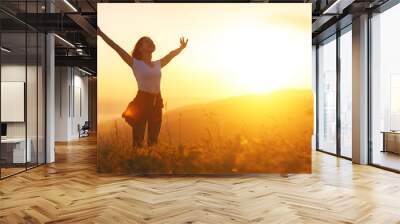 Happy woman   on the sunset in nature in summer with open hands
 Wall mural