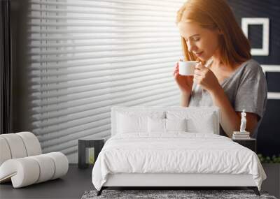 happy young woman meets morning with cup of coffee at window Wall mural