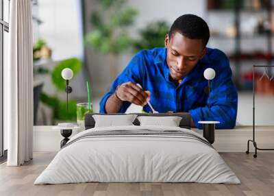 healthy eating. happy young black man eating salad in  morning in kitchen. Wall mural