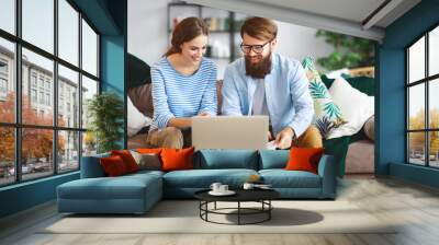 married couple with bills receipts documents and laptop at home Wall mural