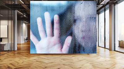 melancholy and sad young  woman  at the window in the rain Wall mural