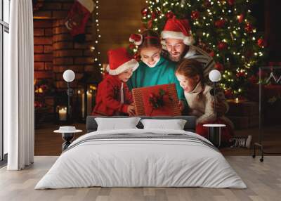 Merry Christmas! happy family mother father and children with magic gift near tree   at home. Wall mural