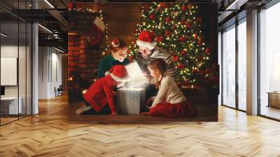 Merry Christmas! happy family mother father and children with magic gift near tree   at home. Wall mural