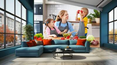 mother with children preparing vegetable salad  . Wall mural