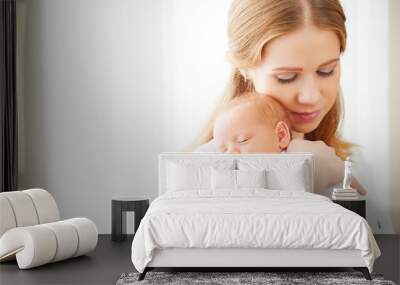 newborn baby in tender embrace of mother Wall mural