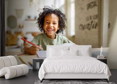 Smiling african american child school boy studying online on laptop at home Wall mural