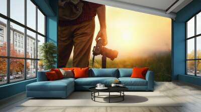 travel photographer. man traveler with camera  at sunset in nature Wall mural