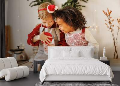 Two excited happy multiracial kids boys open metal tin with traditional Christmas cookies in kitchen Wall mural