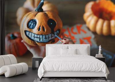 woman artist prepares for halloween and paints pumpkins Wall mural