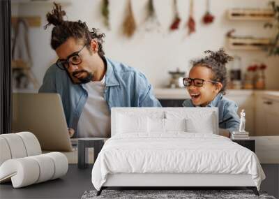 Young african american dad working remotely on laptop with child son at home Wall mural