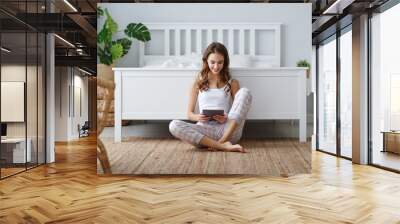 young cute girl with tablet at home in bedroom Wall mural