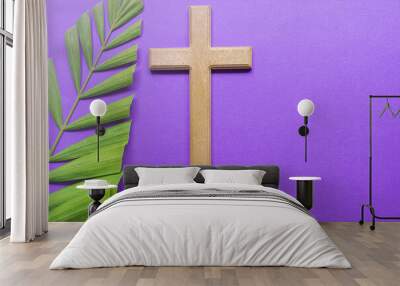 Cross and palm leaves on purple background. Lent season concept. Wall mural