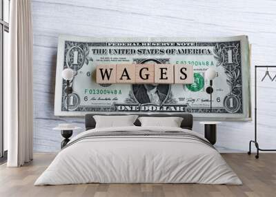 Wages word written on wood block with American Dollar-bills. Directly above. Wall mural