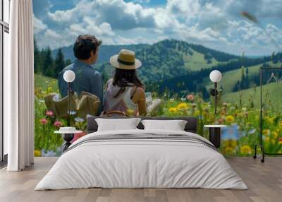 A loving couple enjoys a peaceful picnic surrounded by vibrant wildflowers in a serene meadow. The atmosphere is filled with love and happiness. Wall mural