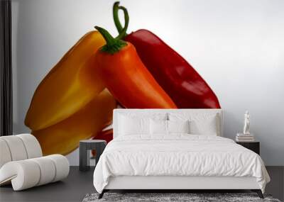 An assortment of red, orange and yellow sweet peppers on a mirror with a white background. Wall mural