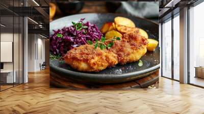 Crispy breaded fried cutlet with baked potatoes and cooked red cabbage on wooden table Wall mural