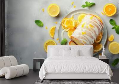 Cut tasty lemon cake with glaze and citrus fruits on light grey textured table, space for text Wall mural