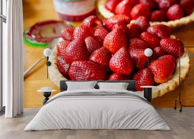 The making of a chilled strawberry glazed pie:  Strawberries have been arranged in a prepared pie shell. Wall mural