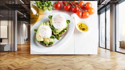 Avocado toast, cherry tomato on wooden background. Breakfast with toast avocado, vegetarian food, healthy diet concept. Healthy sandwich with avocado and poached eggs. Wall mural