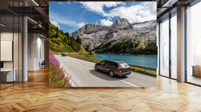 Awesome alpine highland in sunny day. Colorful spring scene. Summer view of Asphalt road near Fedaia lake and Marmolada mountain.  Amazing natural scenery in Dolomites Alps. Picture of wild area Wall mural