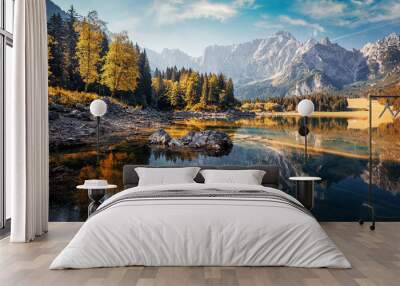 Awesome sunny landscape in the forest. Wonderful Autumn scenery. Picturesque view of nature wild lake. Sun rays through colorful trees. Incredible view on Fusine lakeside. Amazing natural Background Wall mural