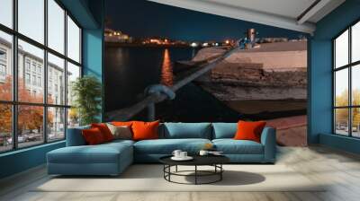 Long-time exposure of a boat in El Gouna lagoon on a view of the illuminated city at night Wall mural