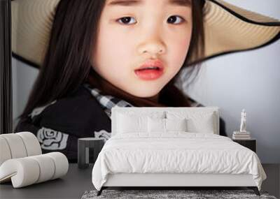 Asian little girl wearing a straw hat on white background Wall mural