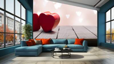 2 beautiful red hearts on a wooden table with hearts background on Valentine's day Wall mural