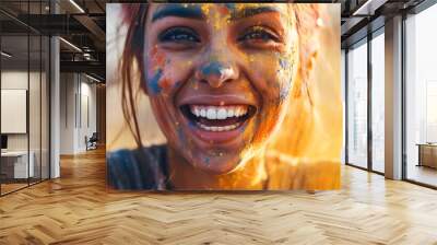 A woman's face reflects joy during Holi festival celebration with colorful paint Wall mural