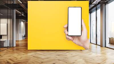 concept - cell phone in a man's hand on yellow background Wall mural