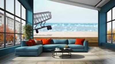 shopping cart on a table on a sunny summer day with the beach in the background Wall mural