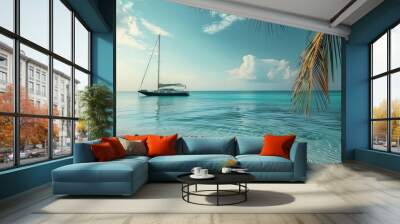 A serene tropical seascape featuring a sailboat anchored near the shore. The water is a pristine, transparent turquoise, reflecting the sky and clouds. Palm tree fronds frame the top right corner of t Wall mural