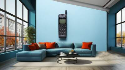 A vintage mobile phone from the 1990s isolated on a blue background. Wall mural