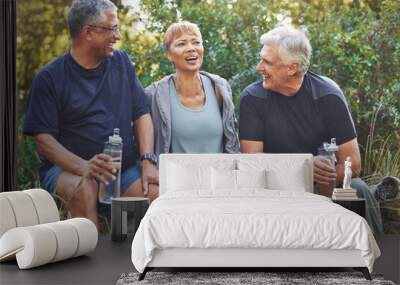 Nature, fitness and senior friends in conversation while sitting in the forest after hiking. Happiness, communication and elderly people talking, bonding and drinking water after outdoor exercise. Wall mural