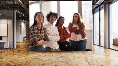 A group of young colleagues in the office are looking at the camera Wall mural