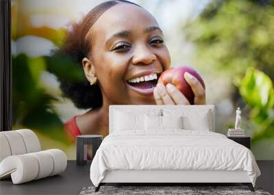 Apple, health and portrait of a black woman biting a fruit on a farm with fresh produce in summer and smile for wellness. Happy, nutrition and young female person on an organic diet for self care Wall mural