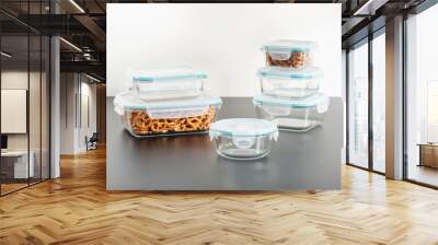 clear plastic containers with food and a transparent glass lids resting side-by-side on a white tabletop Wall mural