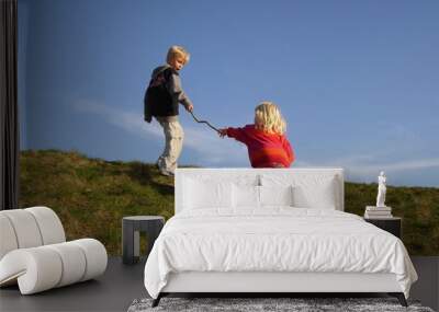 little girl reaching out for help from her older, helpful brother Wall mural