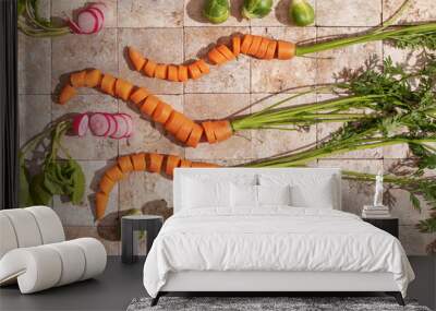 Bunch of carrot roots, Brussels sprouts and ripe radishes with green leaves on stone tales of earth tones top view. Healthy eating and dieting food concept. Wall mural