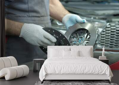 Spare parts for cars. Car clutch kit: drive disc, driven disc and exhaust bearing. An auto mechanic inspects the technical condition of the parts before installation. Wall mural