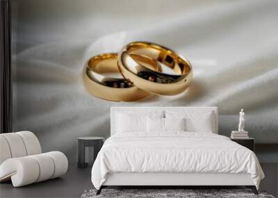  a close up of two gold wedding rings on a white bed sheet with a white blanket in the background and a close up of two gold wedding rings on a white bed sheet. Wall mural