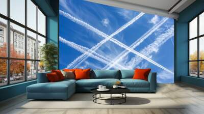   A group of contrails forming a cross in the blue sky as they fly Wall mural