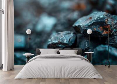  A pile of black rocks sits atop a pile of blue rocks, which in turn rests upon another pile of black rocks Wall mural